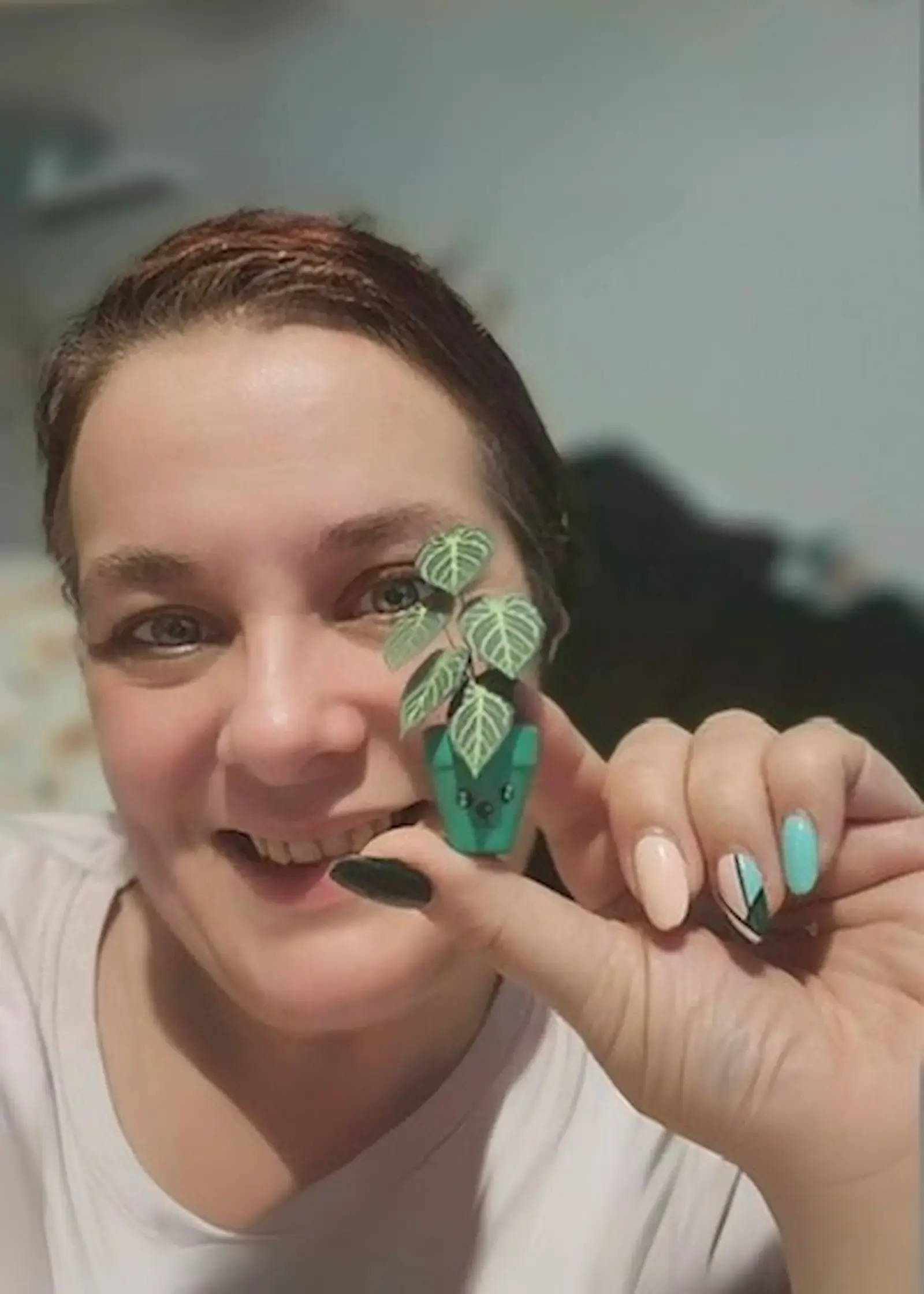 Customer holding a miniature paper Crystal Hope plant in a small green pot
