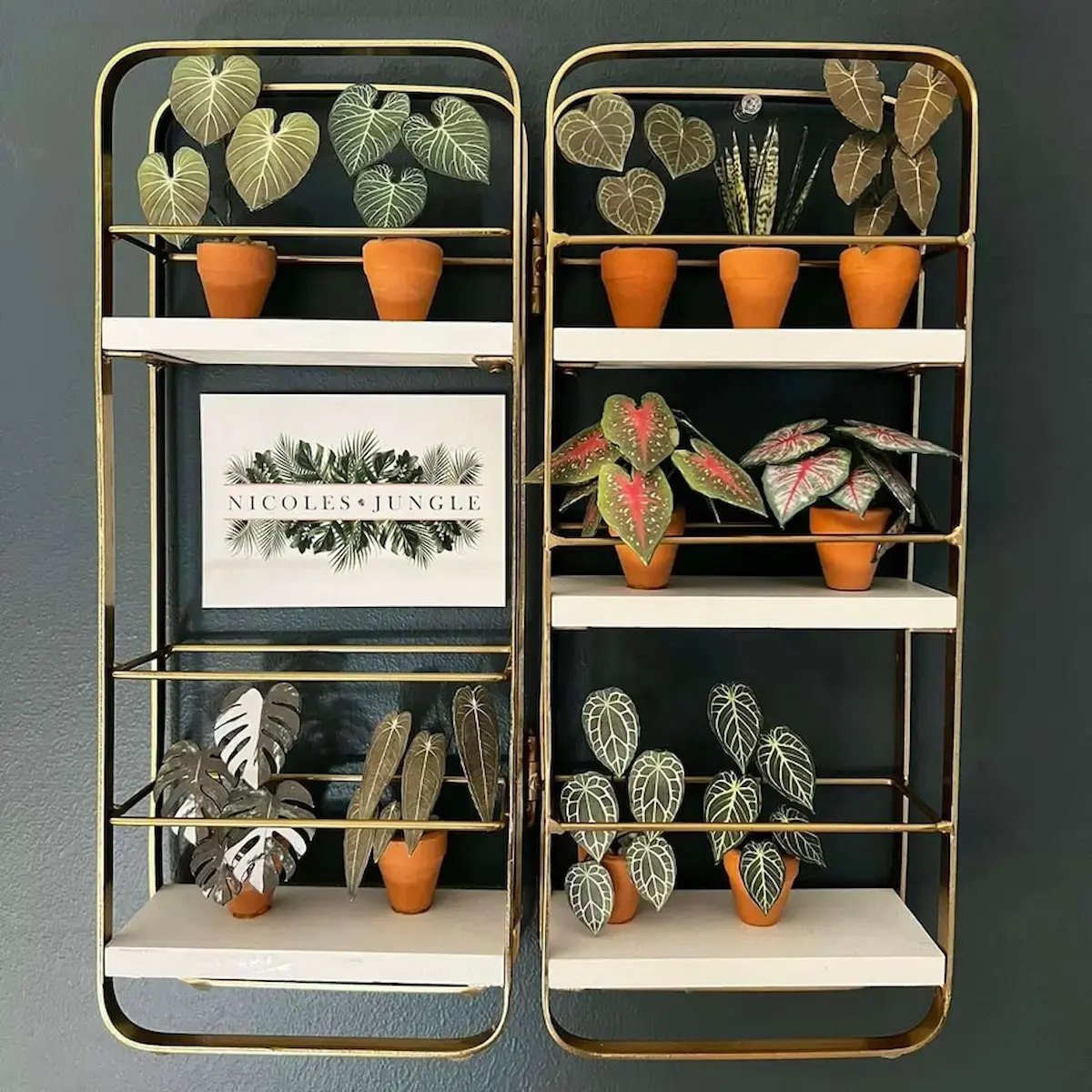 Gold wall shelves displaying miniature paper plants and logo print