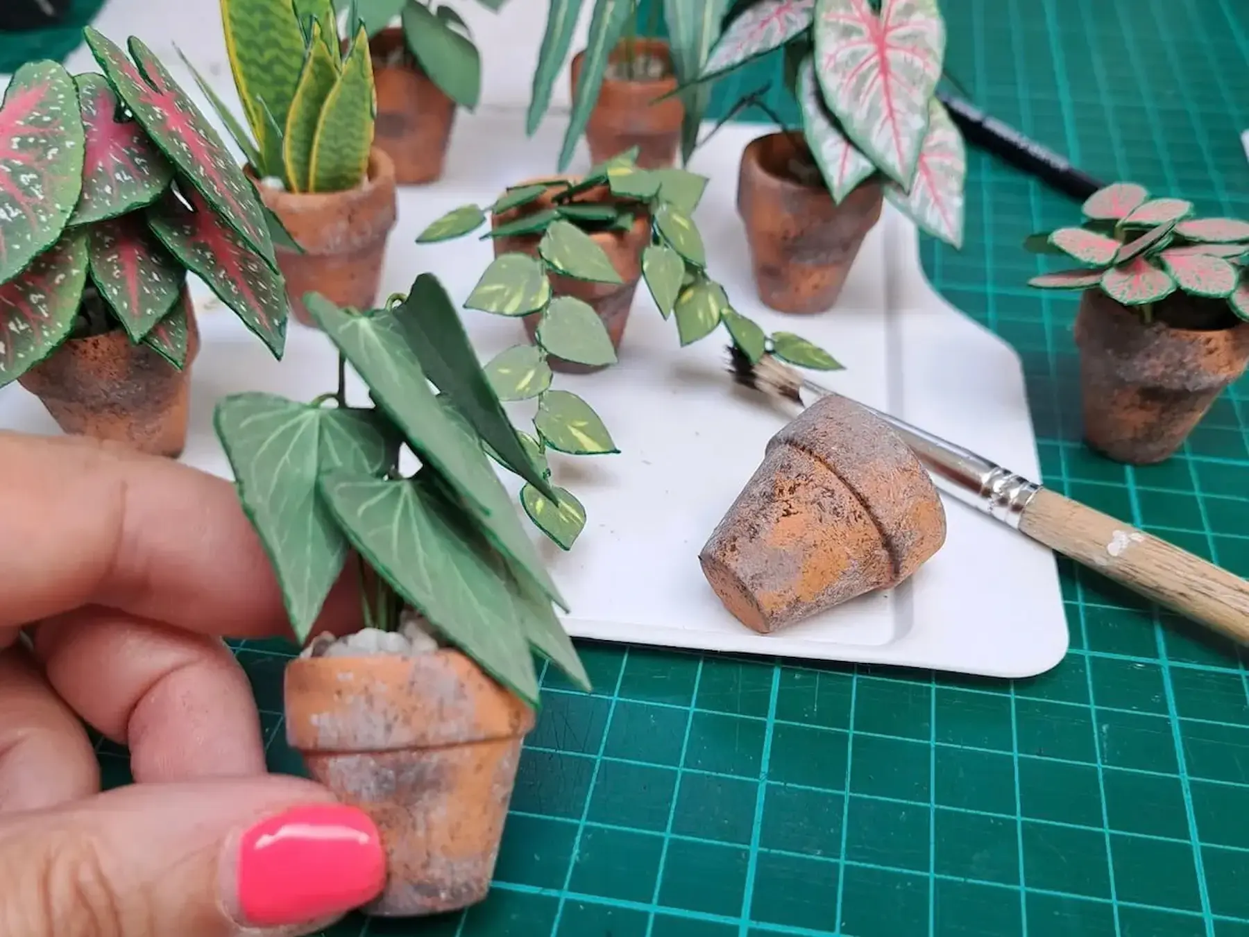 Customer crafting miniature paper plants with pots and tools