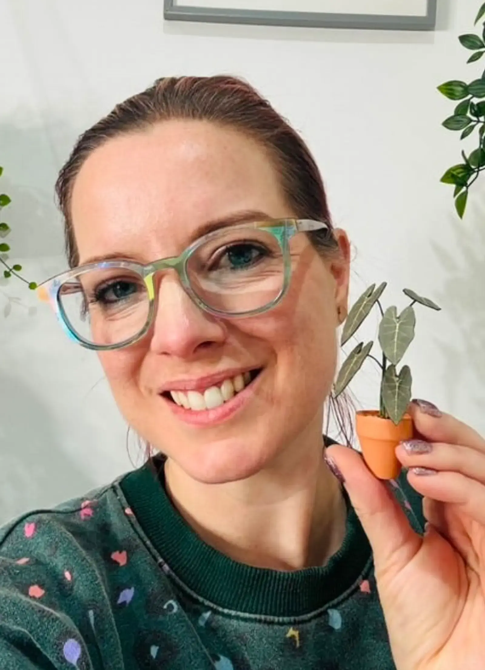 Customer holding a miniature paper Alocasia frydek in a terracotta pot